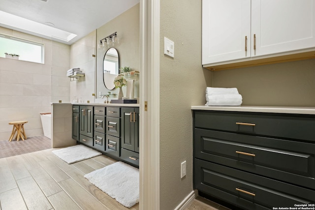 625 Paseo Canada, San Antonio, TX 78232 - full bathroom featuring double vanity, wood finished floors, tile walls, and walk in shower