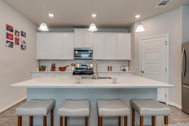 10206 Daylily, Boerne, TX 78006 - kitchen with appliances with stainless steel finishes, light wood-style floors, a sink, a breakfast bar, and recessed lighting
