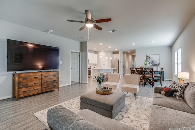 10206 Daylily, Boerne, TX 78006 - living area with ceiling fan, light wood finished floors, and baseboards