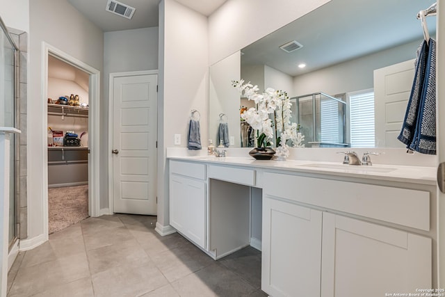 10206 Daylily, Boerne, TX 78006 - bathroom with a stall shower, double vanity, tile patterned floors, a walk in closet, and baseboards