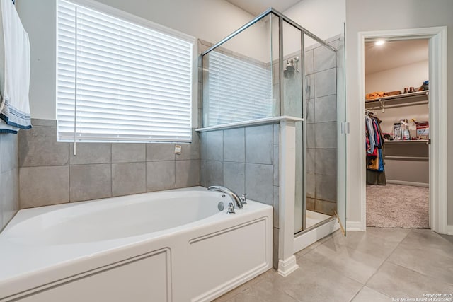 10206 Daylily, Boerne, TX 78006 - bathroom featuring a bath, a stall shower, a spacious closet, tile patterned flooring, and baseboards