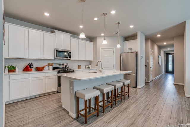 10206 Daylily, Boerne, TX 78006 - kitchen with stainless steel appliances, light wood finished floors, a breakfast bar, a center island with sink, and recessed lighting