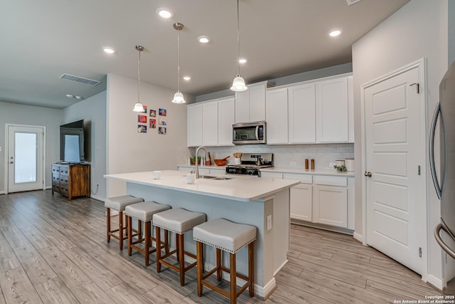 10206 Daylily, Boerne, TX 78006 - kitchen with appliances with stainless steel finishes, a sink, light wood finished floors, decorative backsplash, and recessed lighting