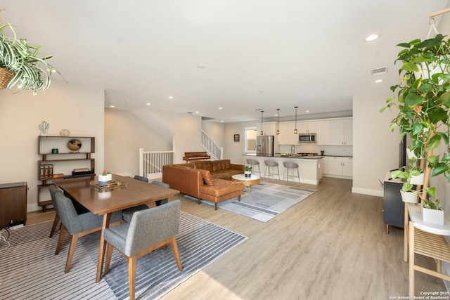 1618 W Lawndale Unit, San Antonio, TX 78209 - dining area featuring light wood finished floors, recessed lighting, stairway, and baseboards