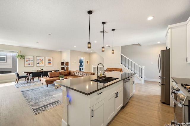 1618 W Lawndale Unit, San Antonio, TX 78209 - kitchen with stainless steel appliances, a sink, light wood finished floors, dark countertops, and recessed lighting