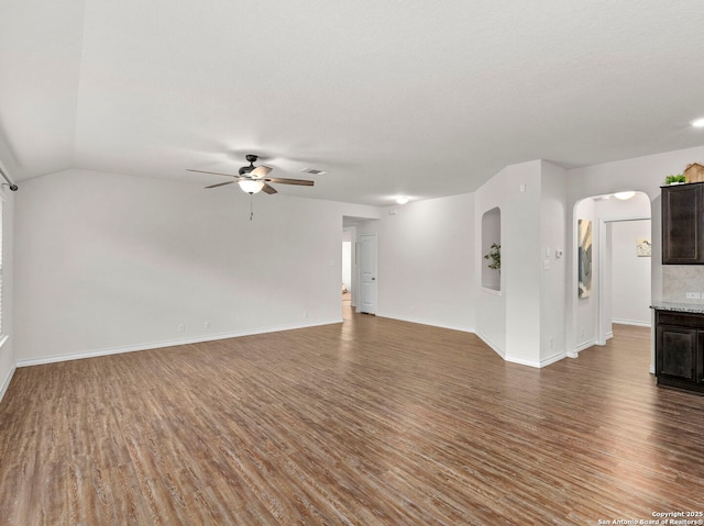 412 Town Frk, Cibolo, TX 78108 - unfurnished living room featuring wood finished floors, ceiling fan, arched walkways, baseboards, and lofted ceiling