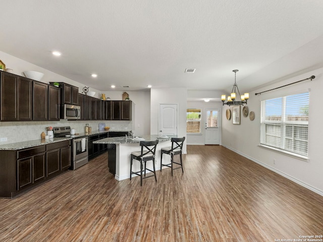412 Town Frk, Cibolo, TX 78108 - kitchen featuring stainless steel appliances, a breakfast bar, a chandelier, wood finished floors, and recessed lighting