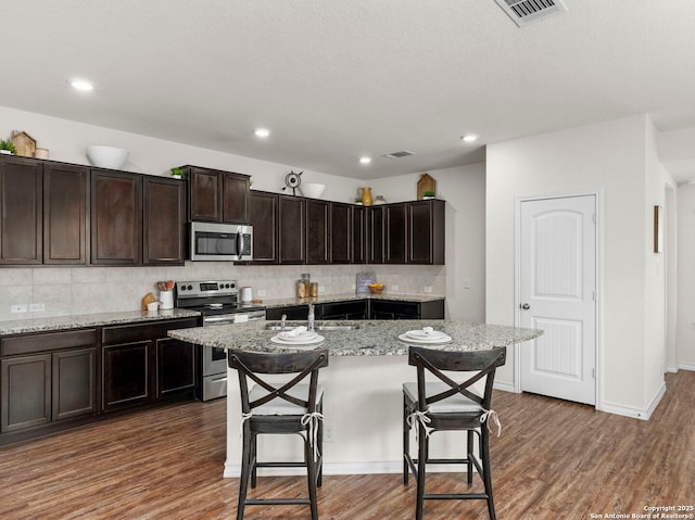 412 Town Frk, Cibolo, TX 78108 - kitchen with stainless steel appliances, a sink, wood finished floors, decorative backsplash, and recessed lighting
