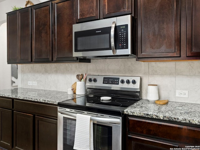 412 Town Frk, Cibolo, TX 78108 - kitchen featuring appliances with stainless steel finishes, decorative backsplash, dark brown cabinetry, and light stone countertops