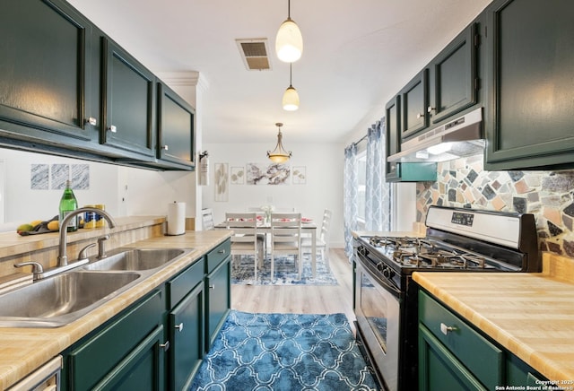 16414 Spruce Cove St, San Antonio, TX 78247 - kitchen with gas range, under cabinet range hood, a sink, light countertops, and decorative light fixtures