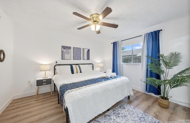 16414 Spruce Cove St, San Antonio, TX 78247 - bedroom with light wood-style flooring, a textured ceiling, ceiling fan, and baseboards