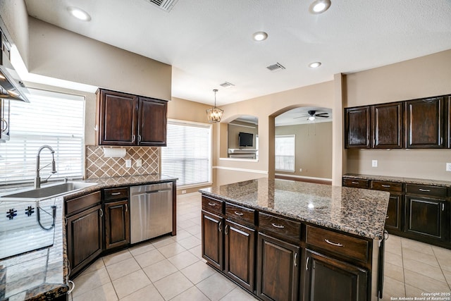5018 Ashton Audrey, San Antonio, TX 78249 - kitchen with stainless steel dishwasher, a sink, light tile patterned floors, decorative backsplash, and exhaust hood