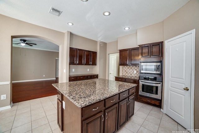 5018 Ashton Audrey, San Antonio, TX 78249 - kitchen featuring stainless steel appliances, light tile patterned floors, backsplash, a kitchen island, and ceiling fan