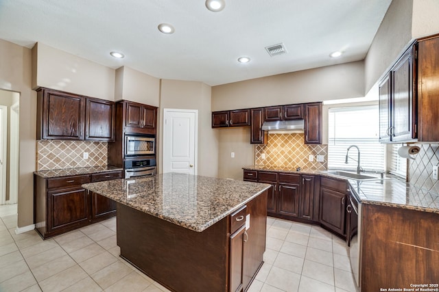 5018 Ashton Audrey, San Antonio, TX 78249 - kitchen featuring a sink, under cabinet range hood, appliances with stainless steel finishes, dark stone countertops, and recessed lighting
