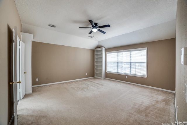 5018 Ashton Audrey, San Antonio, TX 78249 - carpeted empty room featuring a ceiling fan, baseboards, a textured ceiling, vaulted ceiling, and built in shelves