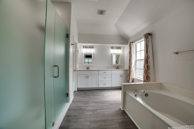 5018 Ashton Audrey, San Antonio, TX 78249 - full bathroom with a shower stall, double vanity, a garden tub, lofted ceiling, and wood finished floors