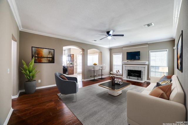 5018 Ashton Audrey, San Antonio, TX 78249 - living area with arched walkways, a ceiling fan, wood-type flooring, ornamental molding, and a fireplace