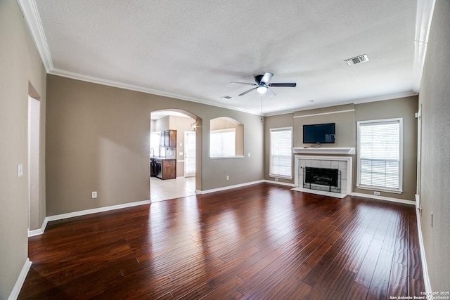 5018 Ashton Audrey, San Antonio, TX 78249 - unfurnished living room featuring a ceiling fan, arched walkways, crown molding, baseboards, and hardwood / wood-style flooring