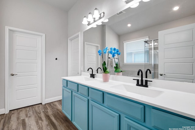 2423 Olive Way, San Antonio, TX 78259 - bathroom featuring double vanity, wood finished floors, a stall shower, and baseboards