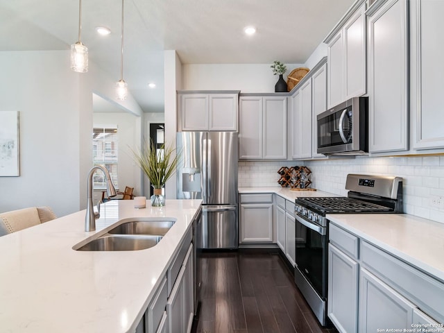 11547 Lightning Way, San Antonio, TX 78245 - kitchen featuring appliances with stainless steel finishes, a sink, dark wood finished floors, decorative backsplash, and decorative light fixtures