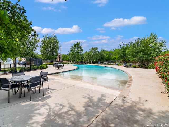11547 Lightning Way, San Antonio, TX 78245 - community pool featuring a patio, outdoor dining space, and view of scattered trees