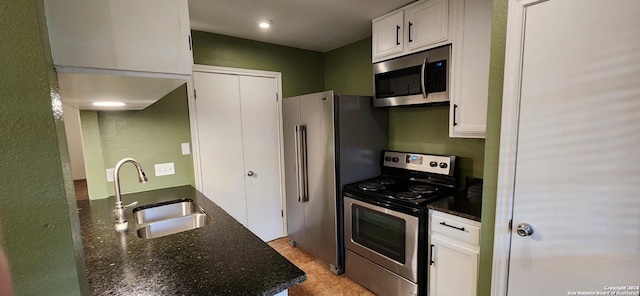 8611 Datapoint Unit 59, San Antonio, TX 78229 - kitchen with appliances with stainless steel finishes, a sink, white cabinetry, and dark stone countertops