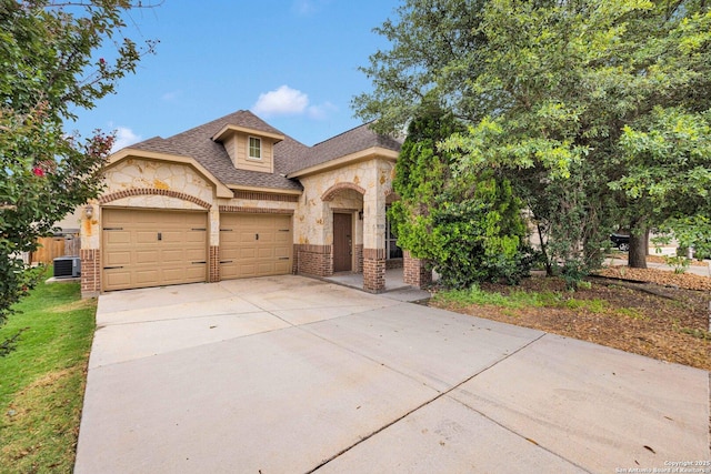 9510 Sun Ml, San Antonio, TX 78254 - view of front of house with brick siding, an attached garage, central AC, stone siding, and driveway