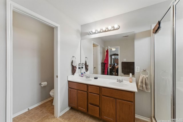 10715 Black Wolf Bay, San Antonio, TX 78245 - bathroom featuring toilet, double vanity, a shower with door, baseboards, and tile patterned flooring