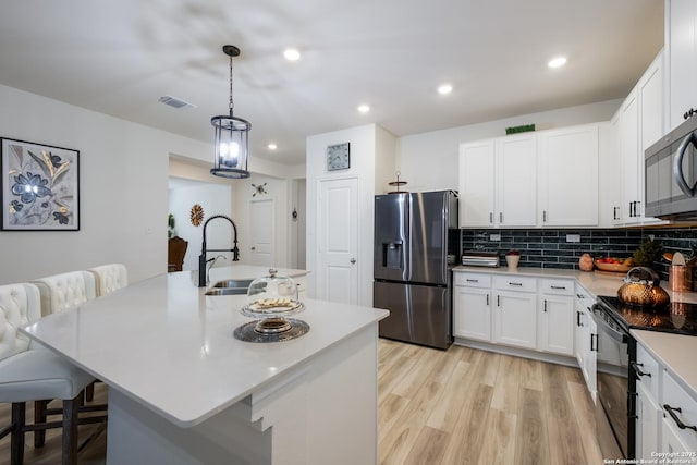 5266 Anzueto, San Antonio, TX 78261 - kitchen with stainless steel appliances, a sink, light countertops, white cabinets, and recessed lighting