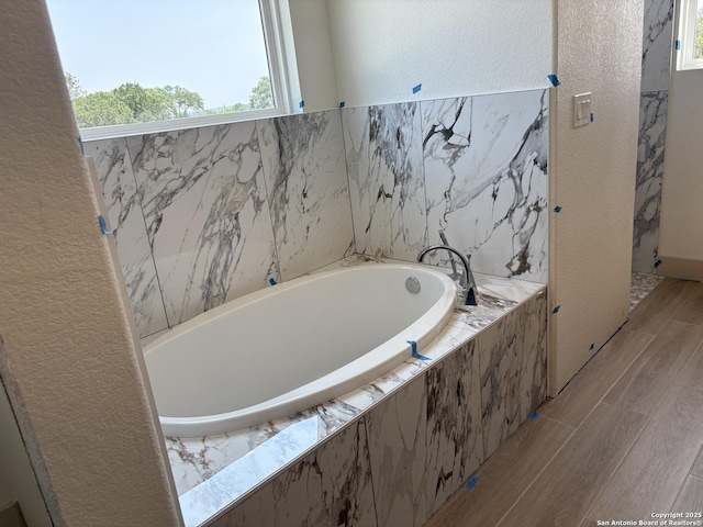 811 Horseshoe Fls, Bandera, TX 78003 - full bathroom with a bath, wood finished floors, and a textured wall
