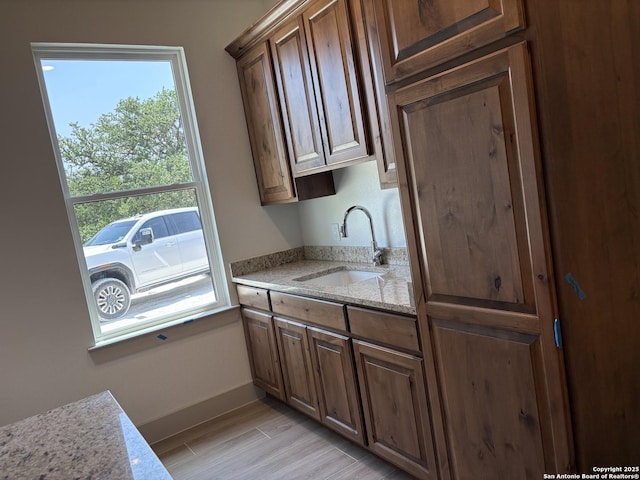 811 Horseshoe Fls, Bandera, TX 78003 - kitchen featuring a sink, baseboards, light wood-style flooring, and light stone countertops