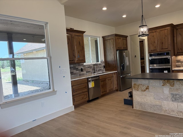 811 Horseshoe Fls, Bandera, TX 78003 - kitchen with stainless steel appliances, tasteful backsplash, a sink, light wood-style floors, and recessed lighting