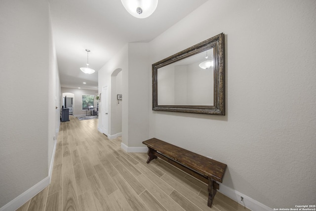 12322 Saddle Up Dr, San Antonio, TX 78254 - hallway with baseboards, light wood-style floors, and arched walkways