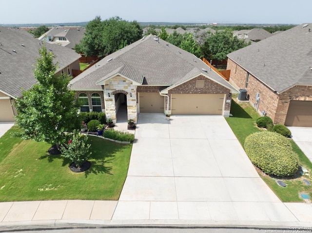 12322 Saddle Up Dr, San Antonio, TX 78254 - view of front of property featuring an attached garage, concrete driveway, a front yard, and stone siding