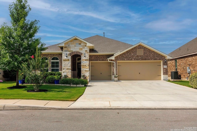 12322 Saddle Up Dr, San Antonio, TX 78254 - french country home featuring a garage, central AC unit, a front yard, driveway, and stone siding