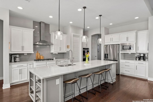 3130 Running Fawn, San Antonio, TX 78261 - kitchen featuring wall chimney range hood, a sink, appliances with stainless steel finishes, arched walkways, and decorative backsplash
