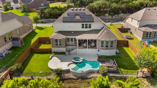 3130 Running Fawn, San Antonio, TX 78261 - back of property featuring roof mounted solar panels, brick siding, a patio, a pool with connected hot tub, and roof with shingles