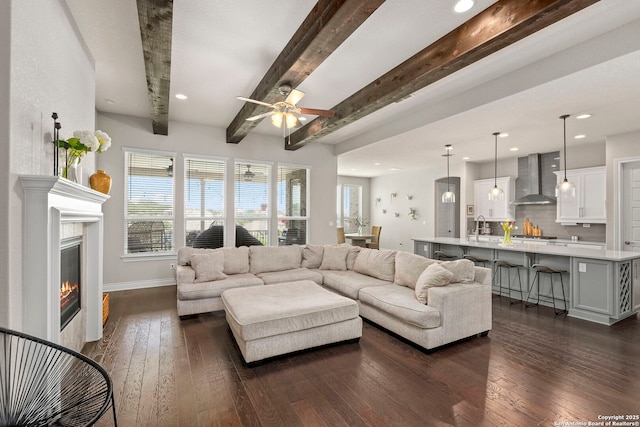 3130 Running Fawn, San Antonio, TX 78261 - living room with dark wood-style flooring, ceiling fan, beamed ceiling, baseboards, and a glass covered fireplace