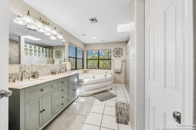 711 Cardinal Dr, Kerrville, TX 78028 - bathroom featuring double vanity, a bath, tile patterned flooring, and backsplash