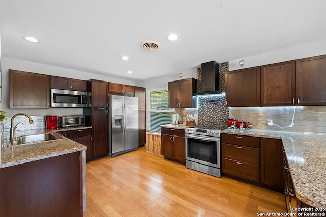 711 Cardinal Dr, Kerrville, TX 78028 - kitchen featuring stainless steel appliances, wall chimney range hood, a sink, tasteful backsplash, and recessed lighting