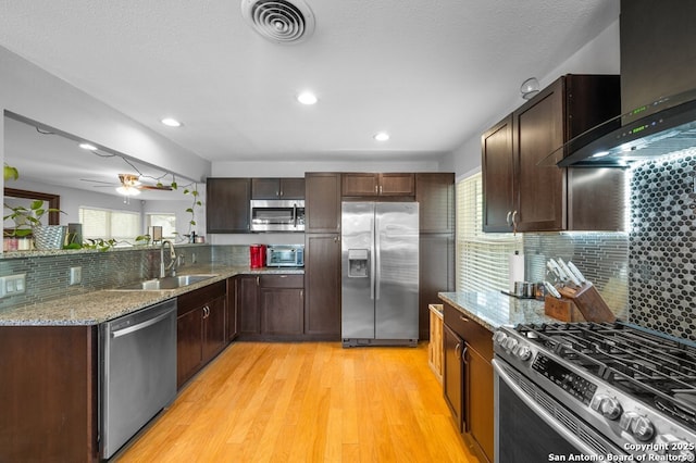 711 Cardinal Dr, Kerrville, TX 78028 - kitchen with appliances with stainless steel finishes, wall chimney range hood, a sink, healthy amount of natural light, and recessed lighting