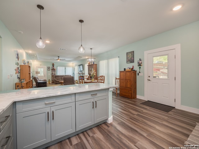 2872 Lakeview Dr, Canyon Lake, TX 78133 - kitchen with gray cabinetry, dark wood-type flooring, open floor plan, light stone countertops, and pendant lighting