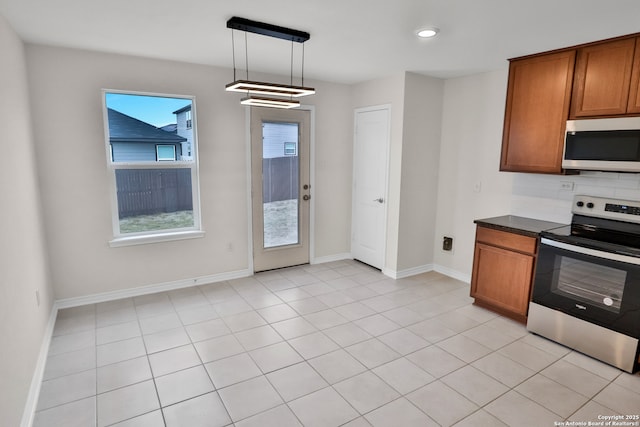 8517 Barefoot Ln, Converse, TX 78109 - kitchen featuring stainless steel electric stove, dark countertops, brown cabinets, backsplash, and baseboards