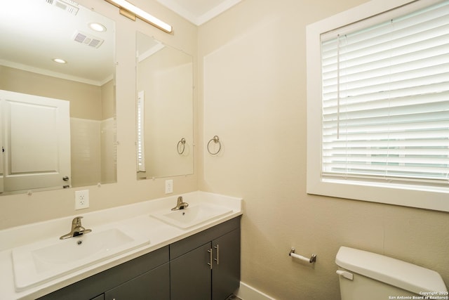 2115 W Houston, San Antonio, TX 78207 - bathroom with double vanity, toilet, ornamental molding, and baseboards