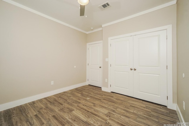 2115 W Houston, San Antonio, TX 78207 - unfurnished bedroom with ornamental molding, wood finished floors, baseboards, a closet, and a ceiling fan