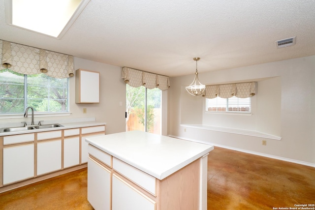 5731 Bypass Trl, San Antonio, TX 78244 - kitchen with a sink, concrete floors, light countertops, a chandelier, and healthy amount of natural light
