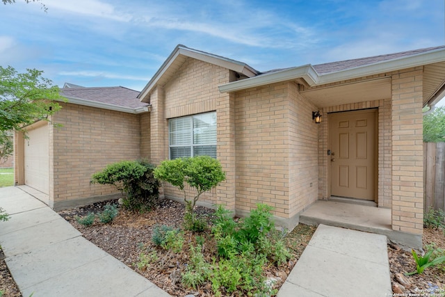 5731 Bypass Trl, San Antonio, TX 78244 - view of exterior entry featuring brick siding, an attached garage, and roof with shingles