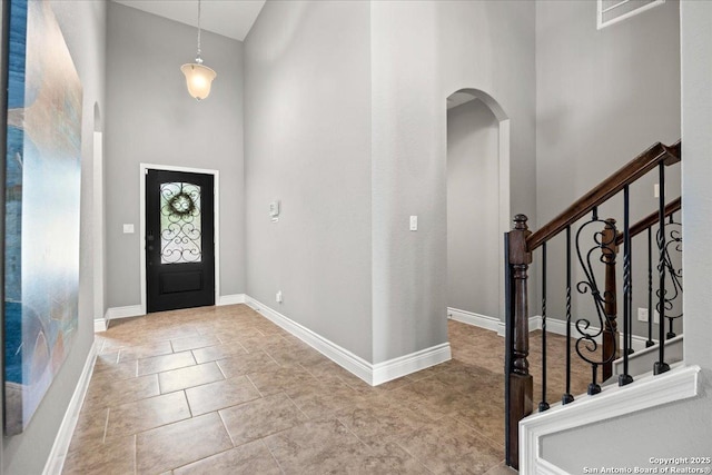 10218 Nate Range, San Antonio, TX 78254 - foyer entrance with arched walkways, a towering ceiling, baseboards, and stairway