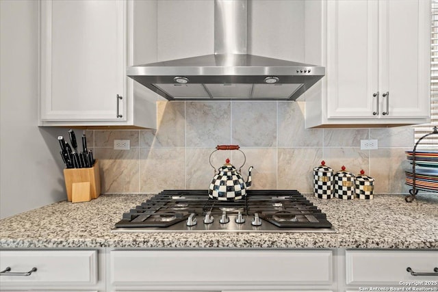 10218 Nate Range, San Antonio, TX 78254 - kitchen featuring wall chimney range hood, stainless steel gas stovetop, white cabinets, decorative backsplash, and light stone counters