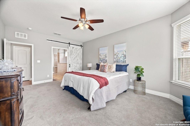 10218 Nate Range, San Antonio, TX 78254 - carpeted bedroom with a barn door, baseboards, ceiling fan, and ensuite bathroom